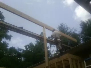 Carpenter setting a ridge beam over a new addition frame — Ice Dam Removal by Roofing Brothers in Peterborough